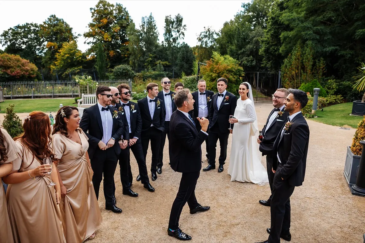 A couple celebrating on the lawn with their wedding party