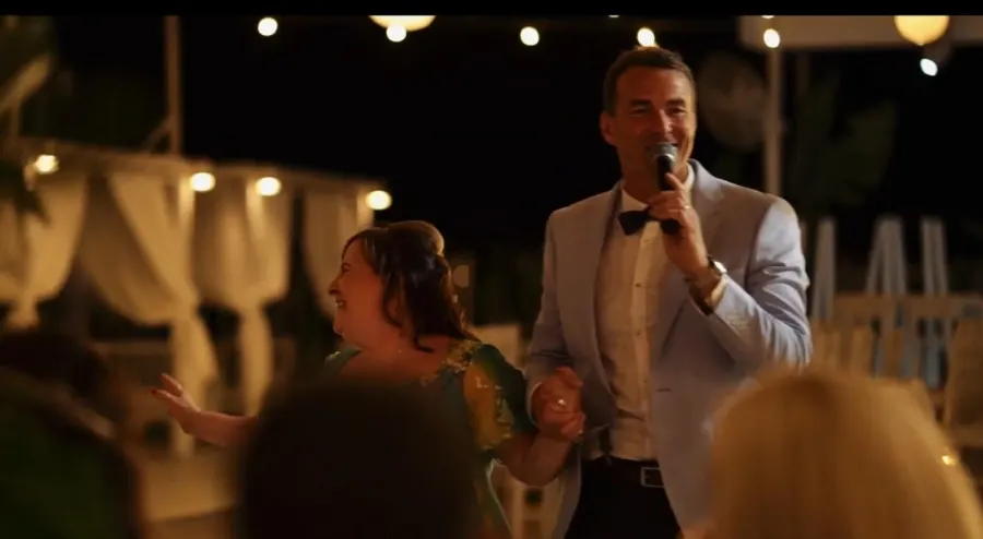 Howard singing hand in hand with a guest on the dance floor in Cyprus