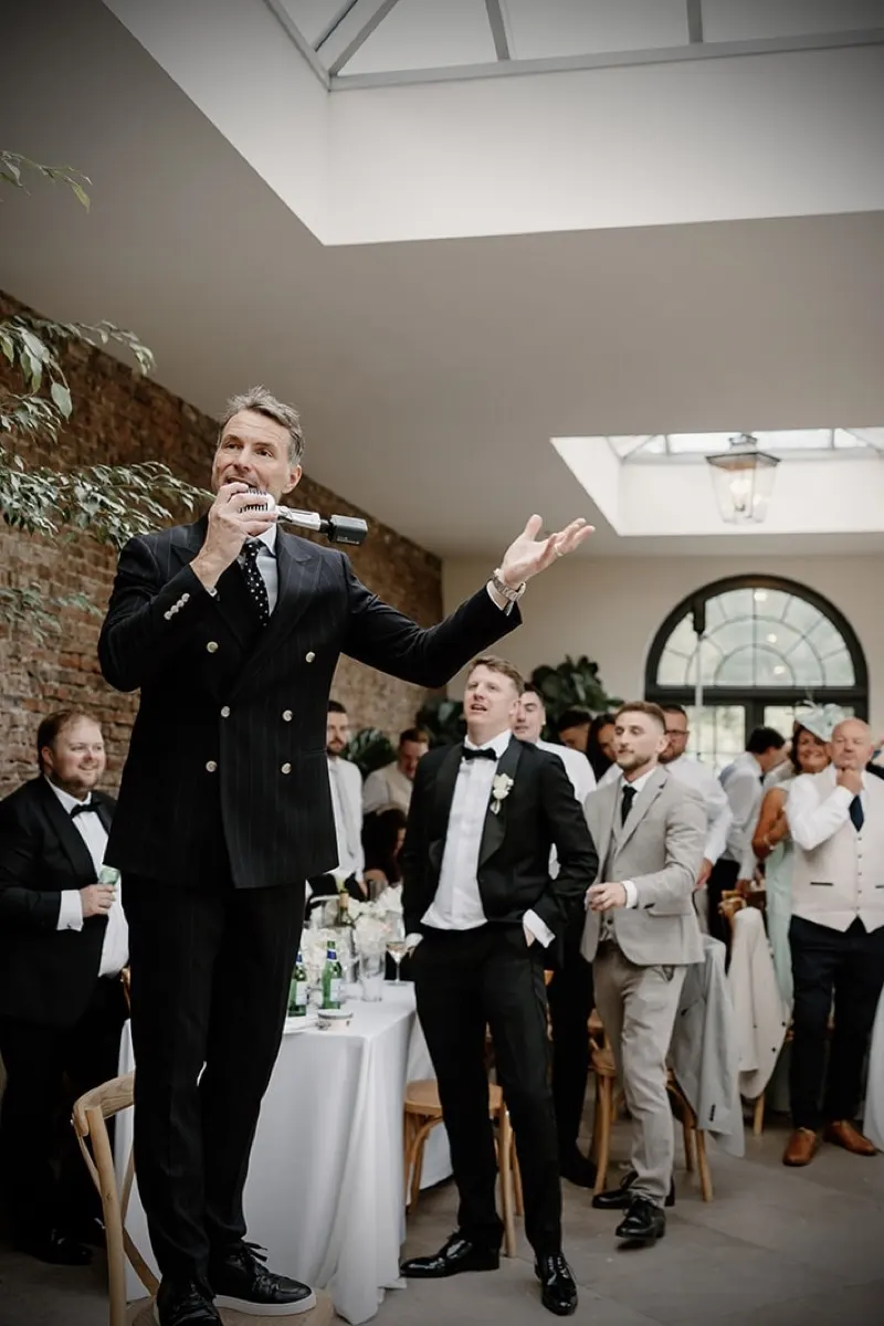 Howard Wing singing in the middle of a full wedding room