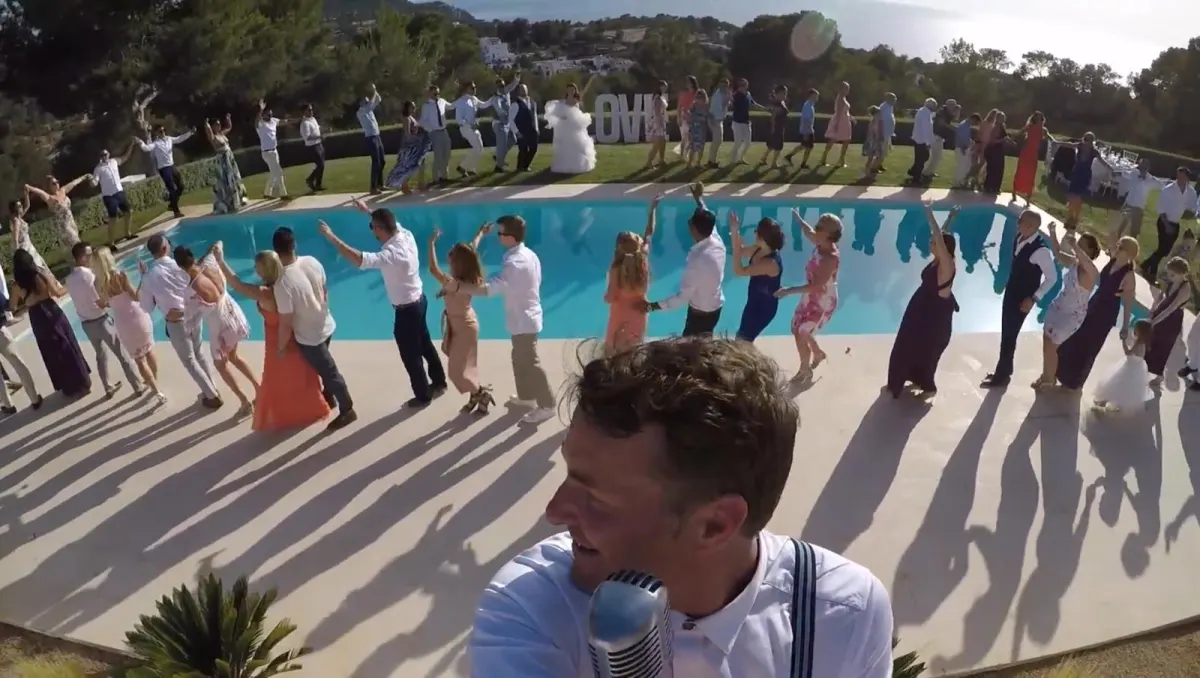The whole wedding circling the pool at an Ibiza villa, Howard on the mic in front