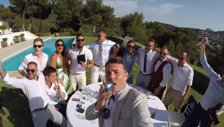 Howard singing at the poolside tables in Ibiza, guests up behind him