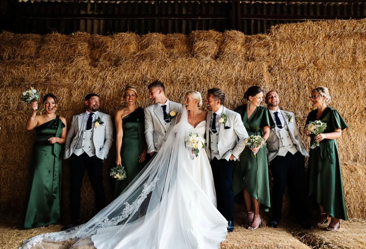 Alex and Craig's wedding party on the hay bales at Owen House Barn