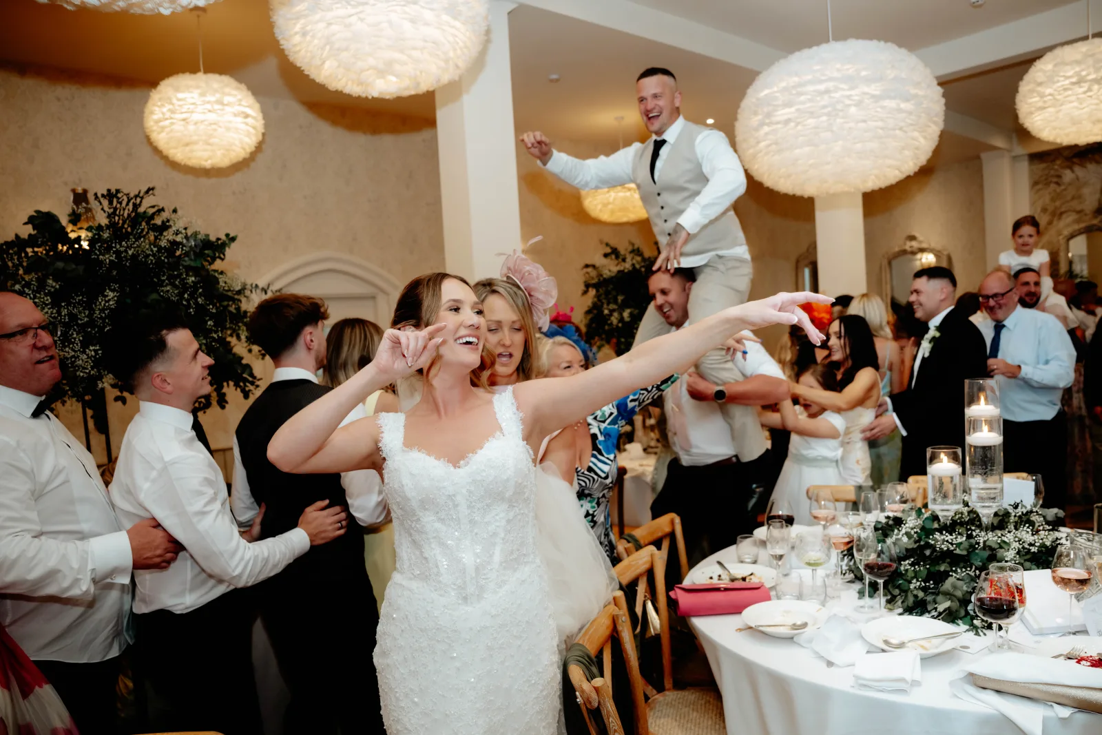 Guests with their arms in the air around the bride at Wennington Hall, Lancaster
