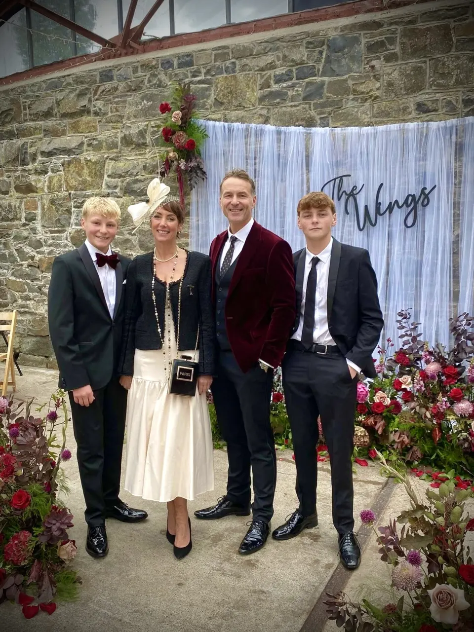 Howard with Samantha, William and Lincoln under a The Wings sign at a wedding
